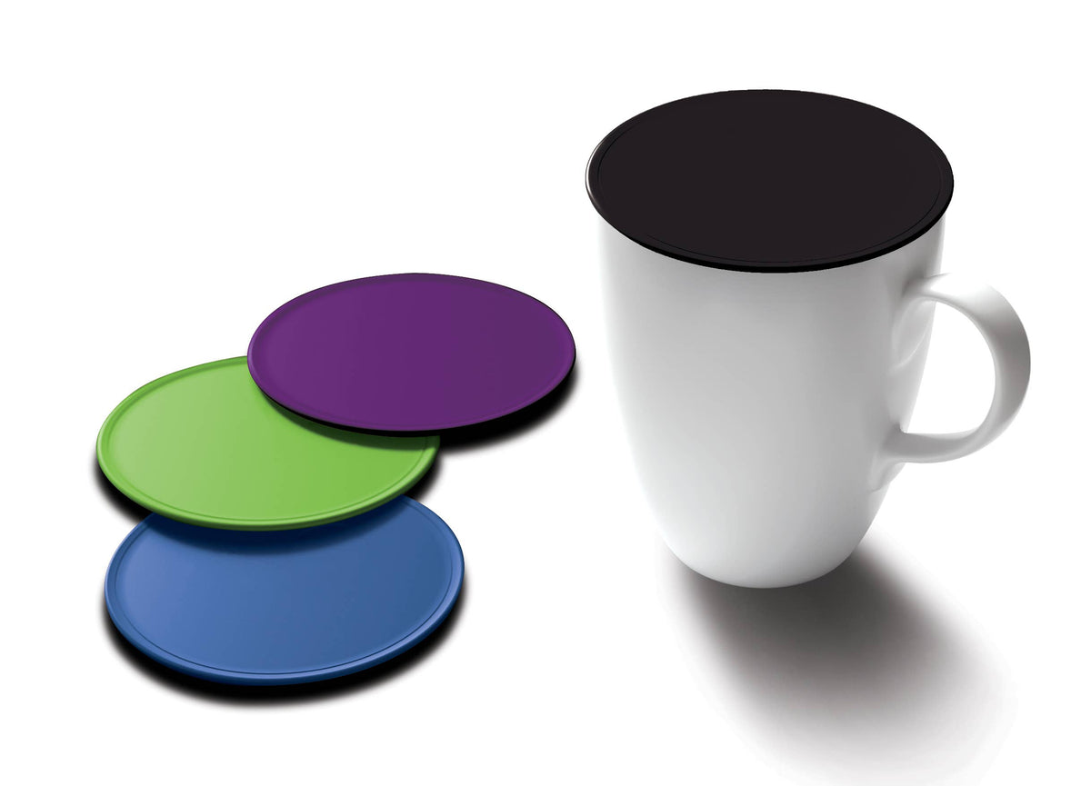 Four round silicone coaster lids in black, purple, green, and blue, shown next to a white ceramic mug on a white background.
