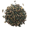 Brown rolled tea with golden tips on a white background