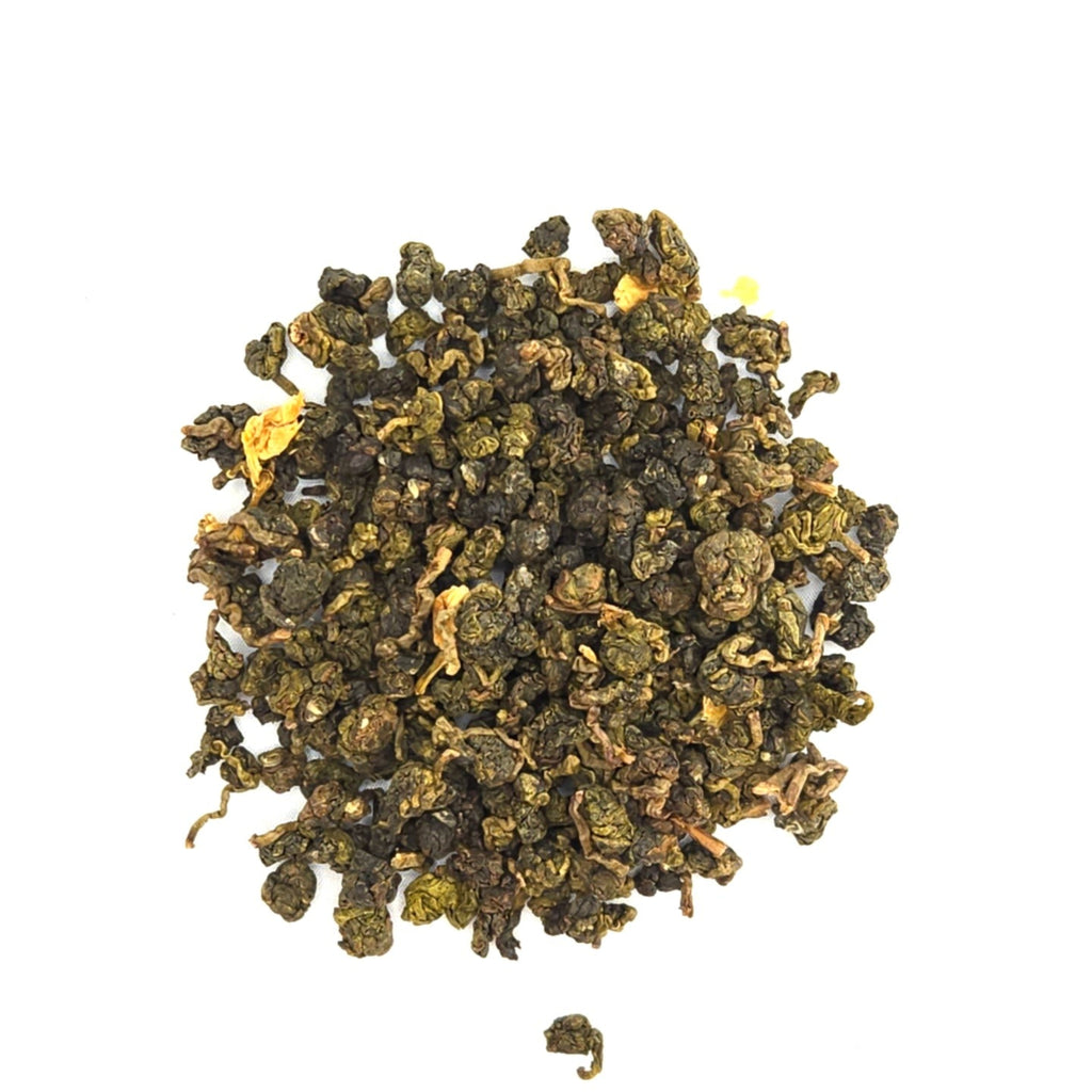 Dry balled oolong tea leaves on a white background