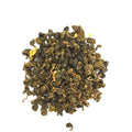 Dry balled oolong tea leaves on a white background